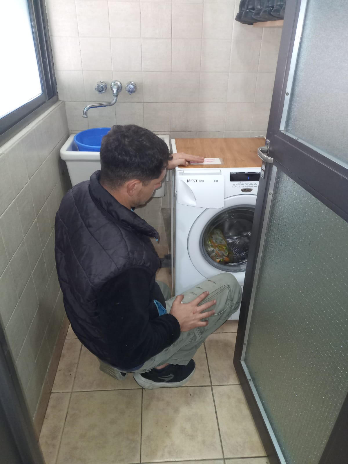 Técnico de N/D Service reparando un lavarropas a domicilio